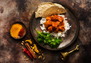 Chikcen Mango Curry mit Reis und Koriander auf einem Teller