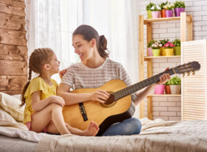 Mutter spielt mit ihrer Tochter Gitarre